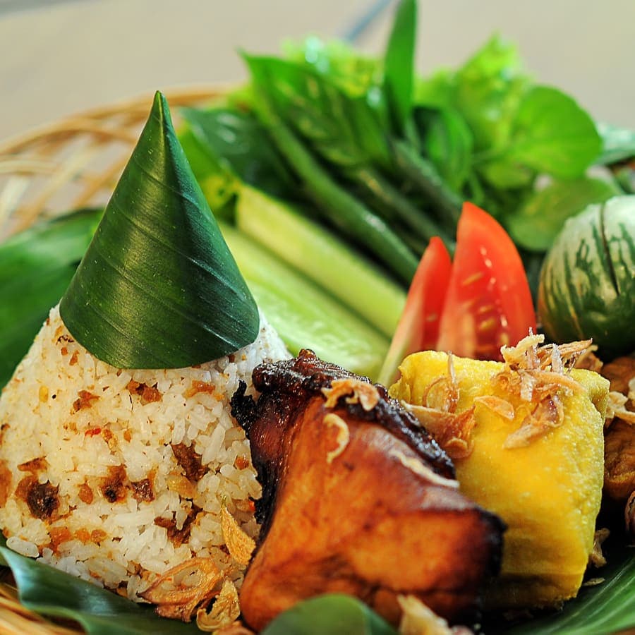 Hidangan khas Sunda: nasi berbumbu, ikan goreng, tahu, tempe, dan lalapan segar beralas daun pisang