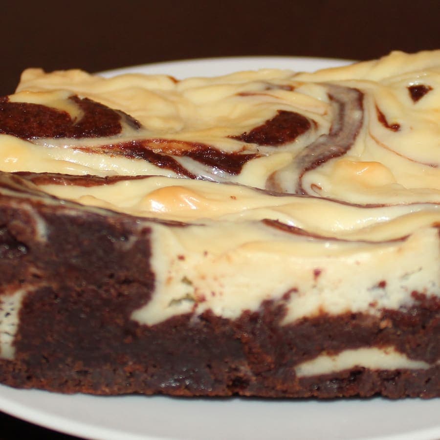 Brownies cream cheese bermotif marmer di atas piring putih