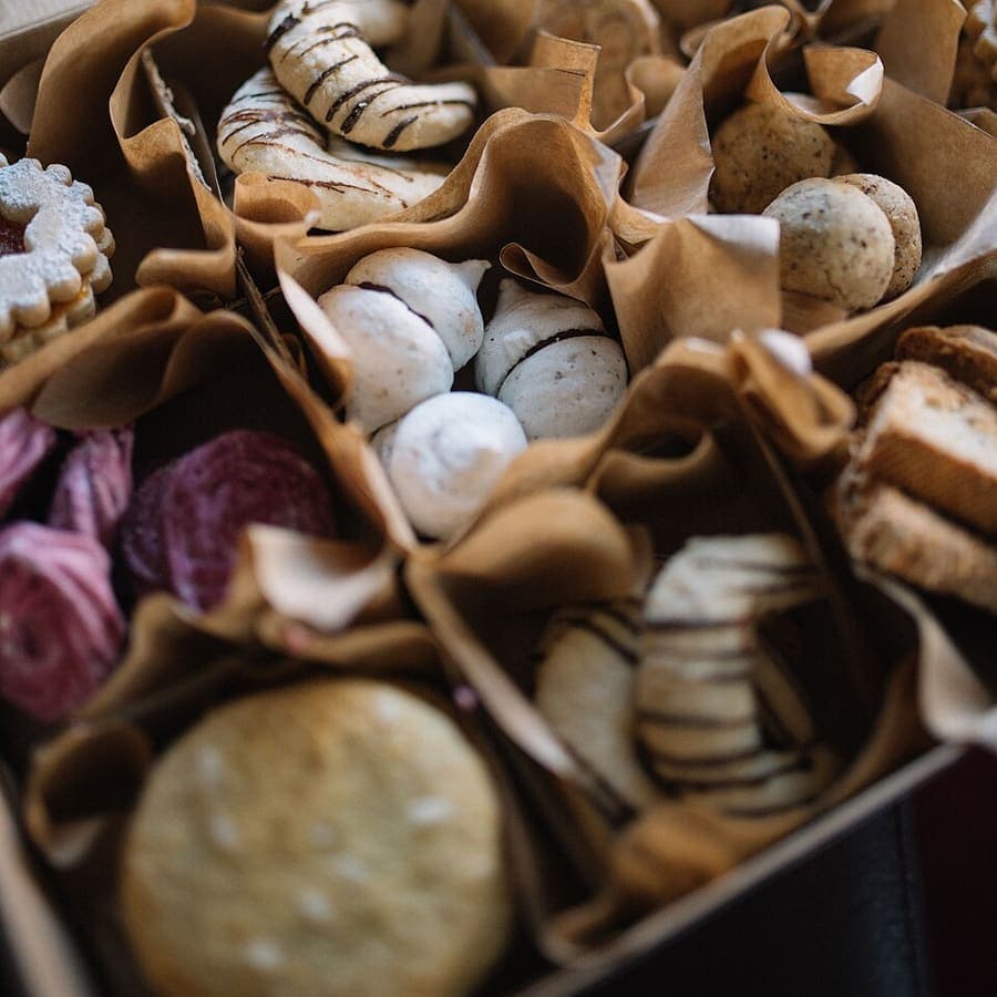Aneka kue kering dan meringue dalam kotak hampers berlapis kertas cokelat